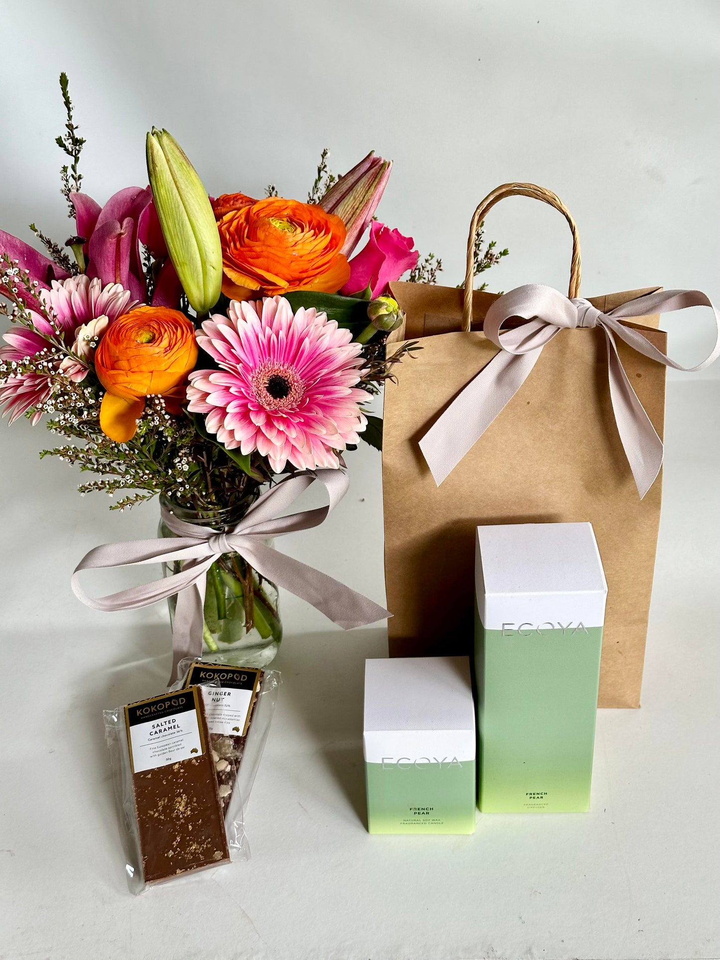 flowers in a jar with a gift bag including chocolate and Ecoya reed diffuser and candle