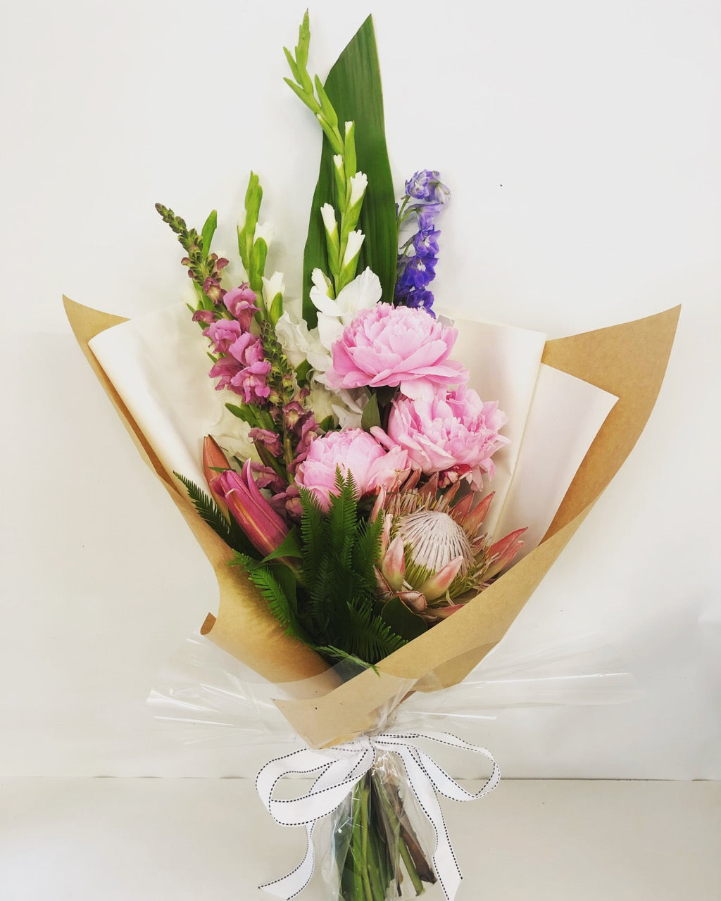 Modern tall flower bouquet gift wrapped in soft colors  for delivery on the Sunshine Coast