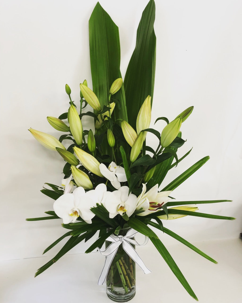 vase arrangement of white lilies and orchids