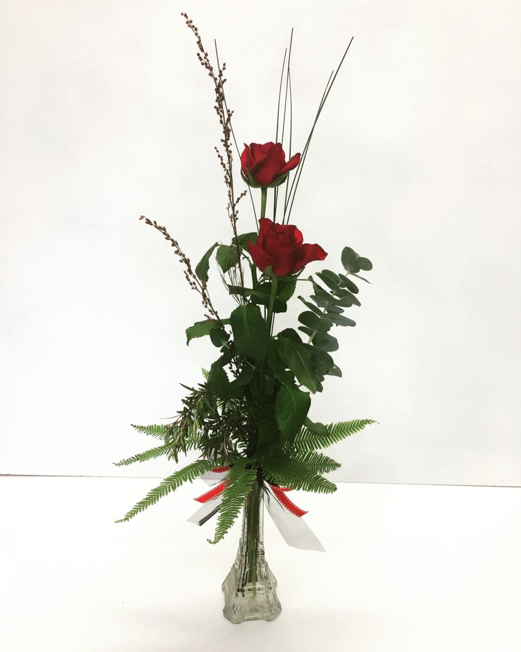 2 roses in a vase with greenery