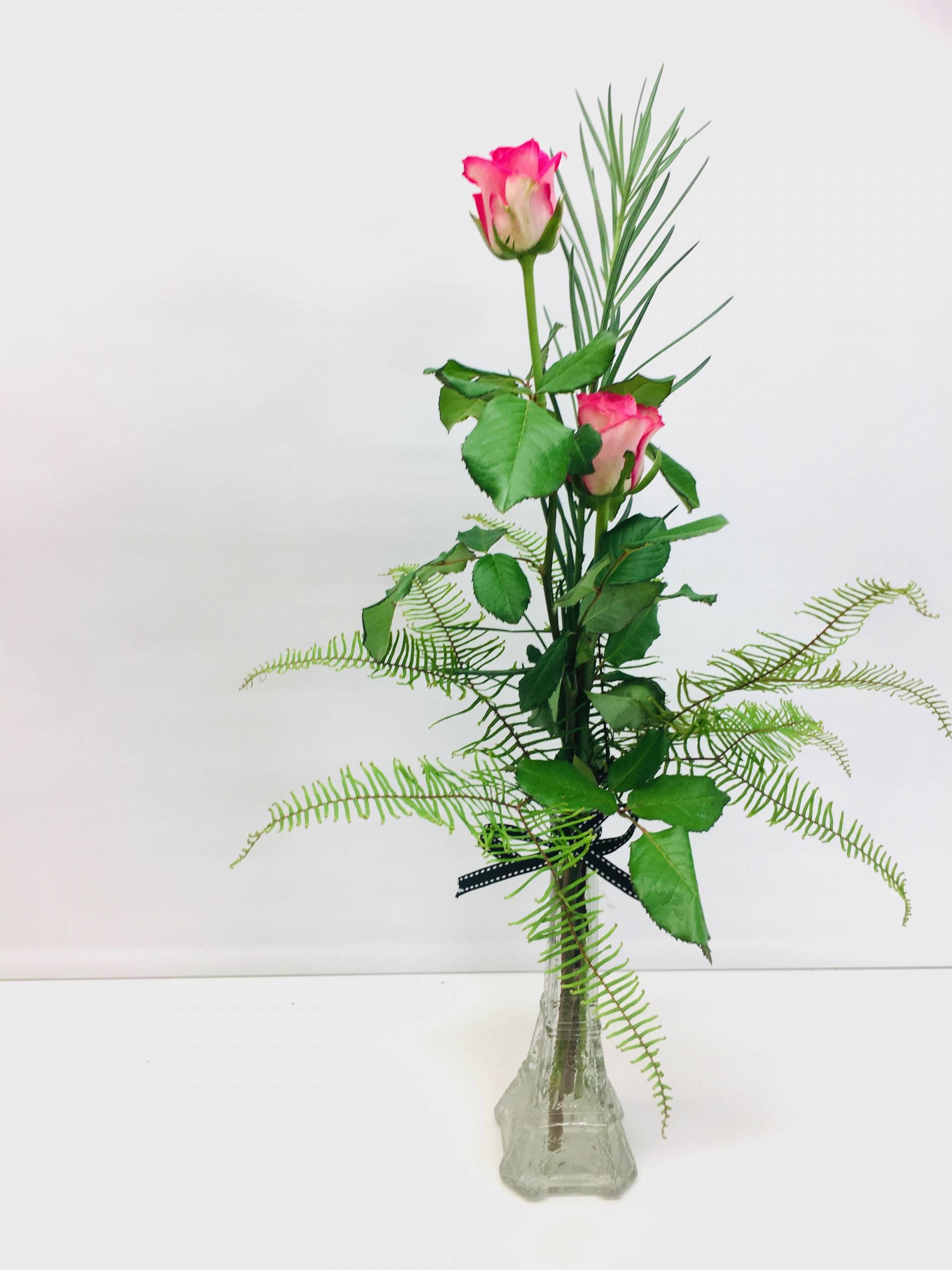 2 roses in a vase with greenery