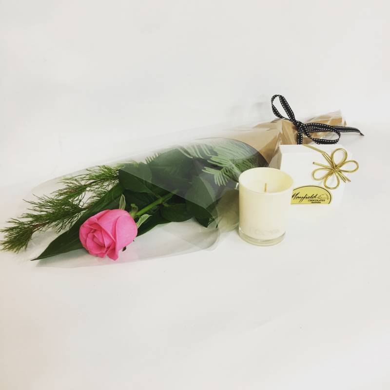 single rose with candle and chocolates